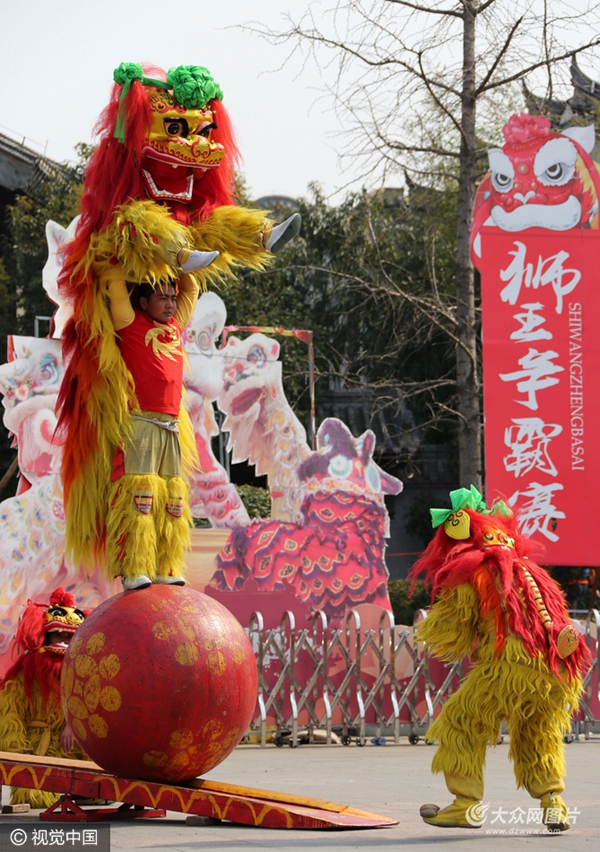 民间艺人在枣庄市台儿庄古城进行狮子滚绣球表演.