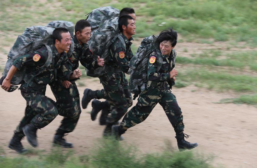 在朱日和训练基地,特战连女兵彭双(右)在五公里越野训练中与男特种兵