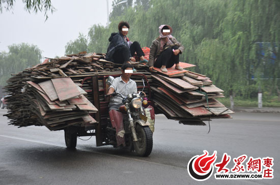 机动三轮车装木板超载 过往车辆纷纷绕行