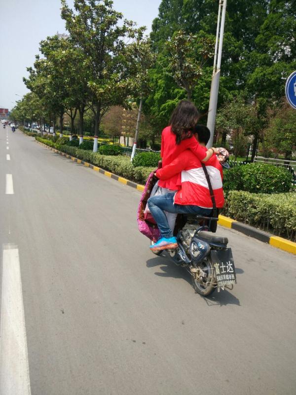 另行人吃驚的是,這名女生並非坐在電動車的後座上而是站在電動車前邊